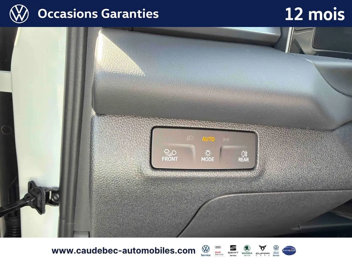 Détail du tableau de bord côté passager du Volkswagen T-Roc blanc 2025 avec commandes d’éclairage automatiques.