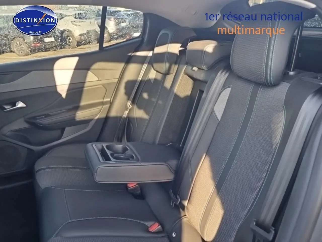 Vue intérieure côté droit de la banquette arrière grise avec accoudoir central et porte-gobelets du Peugeot 408 Hybrid 145 allure 2025.