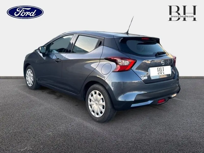 Vue 3/4 arrière droite d'une Nissan Micra gris acier 2018 avec becquet et feux arrière distinctifs.