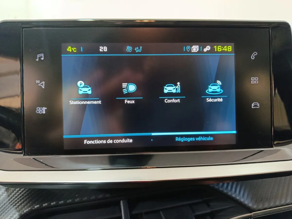 Écran tactile central de la Peugeot 208 Electrique Active Business affichant les réglages de conduite, vue rapprochée intérieure.