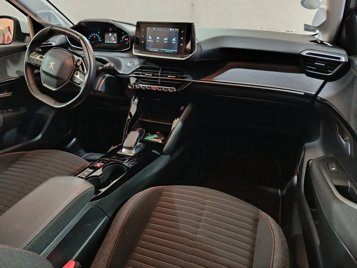 Vue intérieure côté conducteur du tableau de bord et console centrale noire du Peugeot 208 Electrique Active Business 2020.