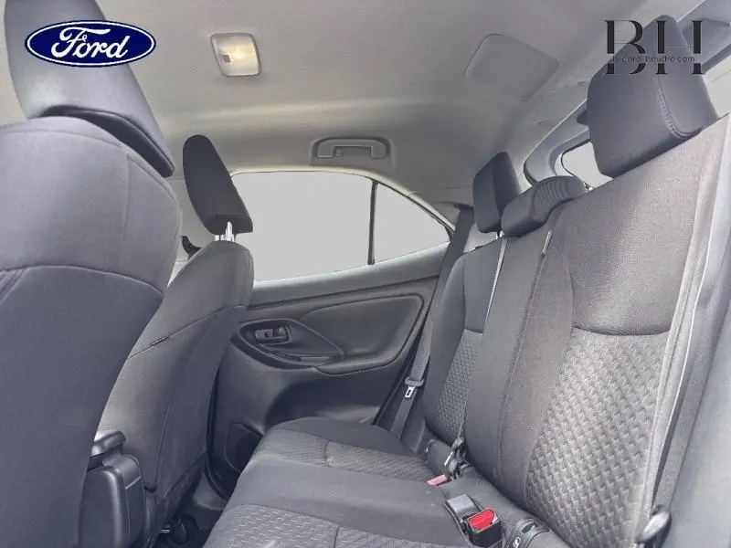 Vue intérieure arrière côté droit de la Toyota Yaris Cross 116h Dynamic 2024 avec sièges tissu gris et appuie-têtes.