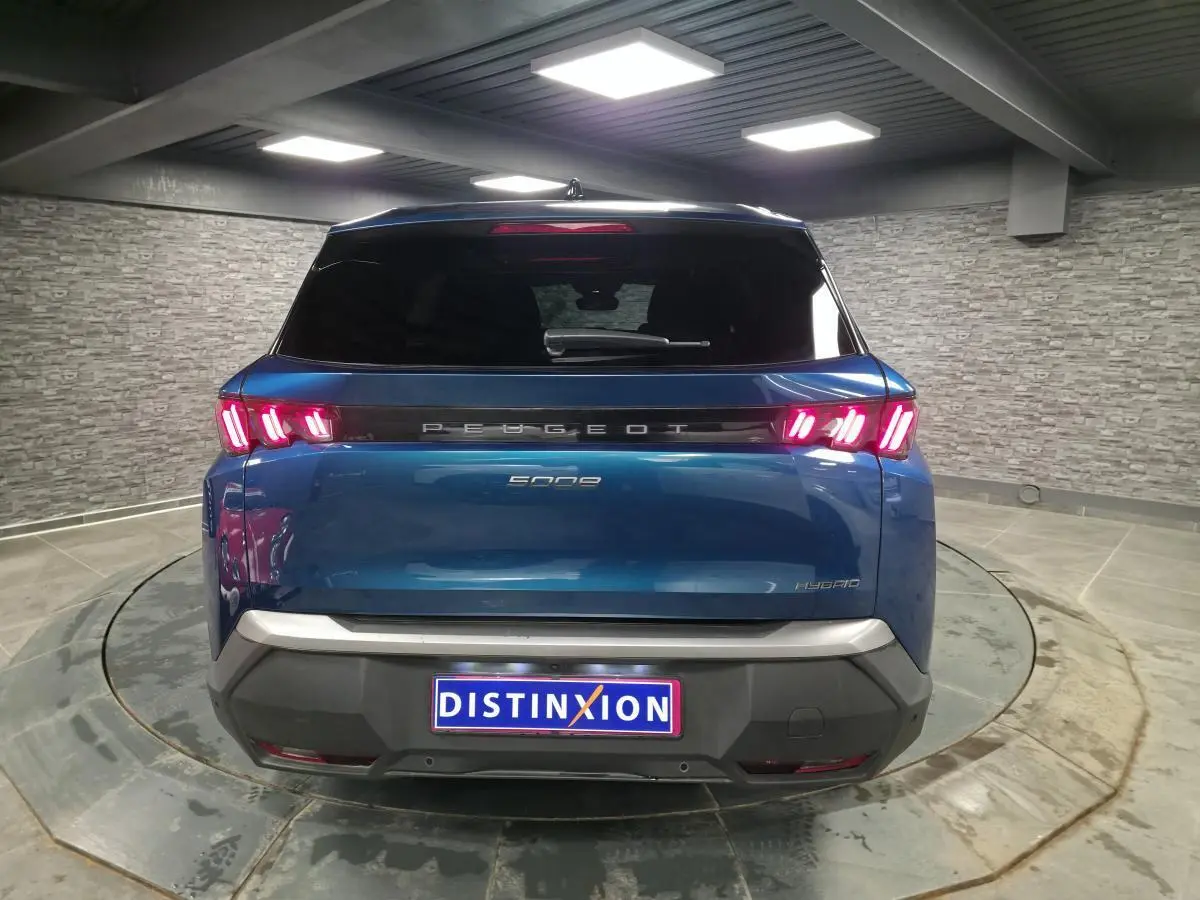 Vue arrière d'un Peugeot 5008 bleu métallisé avec feux arrière LED à 3 griffes et bandeau noir laqué.