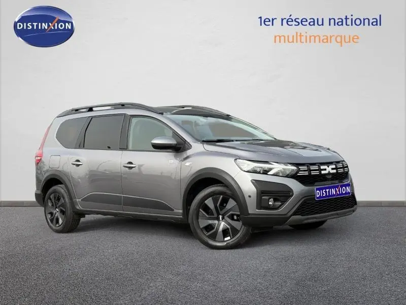 Vue 3/4 avant droit du Dacia Jogger gris schiste métallisé, break familial 7 places avec jantes noires distinctives.