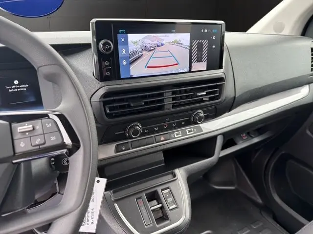 Vue intérieure du tableau de bord du Citroën Jumpy noir 2025, avec écran tactile affichant la caméra de recul et commandes modernes.