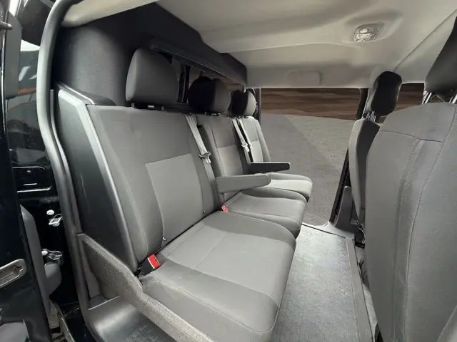 Vue intérieure côté gauche du Citroën Jumpy noir 2025, montrant la banquette arrière 3 places avec accoudoir central.