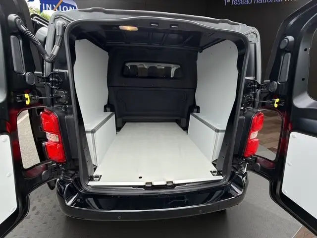 Vue arrière du Citroën Jumpy noir 2025 avec portes ouvertes, montrant l’espace de chargement équipé d’un kit bois blanc.