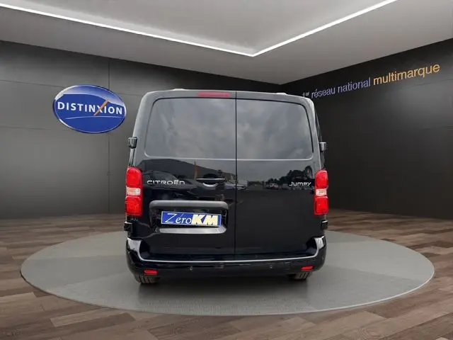 Vue arrière d’un Citroën Jumpy noir 2025 avec portes battantes et feux arrière rouges visibles en intérieur showroom.