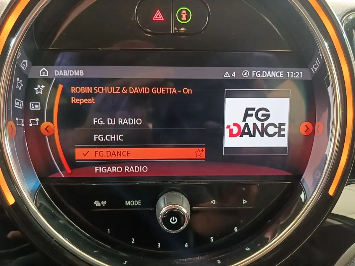 Gros plan sur l’écran tactile central du MINI Countryman gris clair, affichant la radio FG.DANCE en mode DAB.