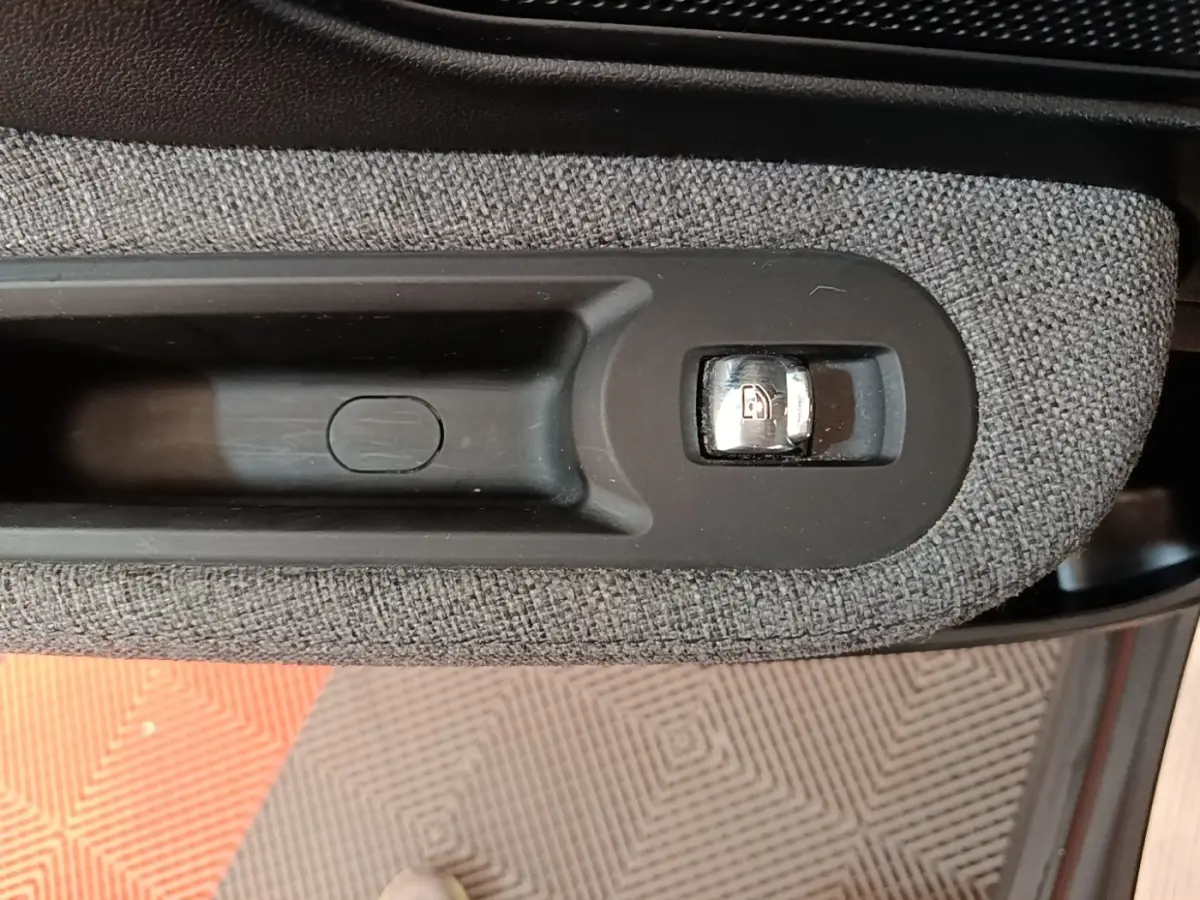 Détail de la commande de verrouillage des portes sur la portière intérieure d’un MINI Countryman gris clair.
