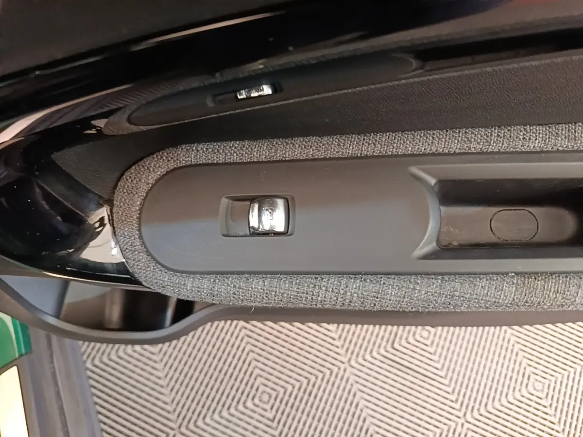 Gros plan sur la poignée intérieure et bouton de verrouillage de porte du MINI Countryman gris clair, vue côté gauche.