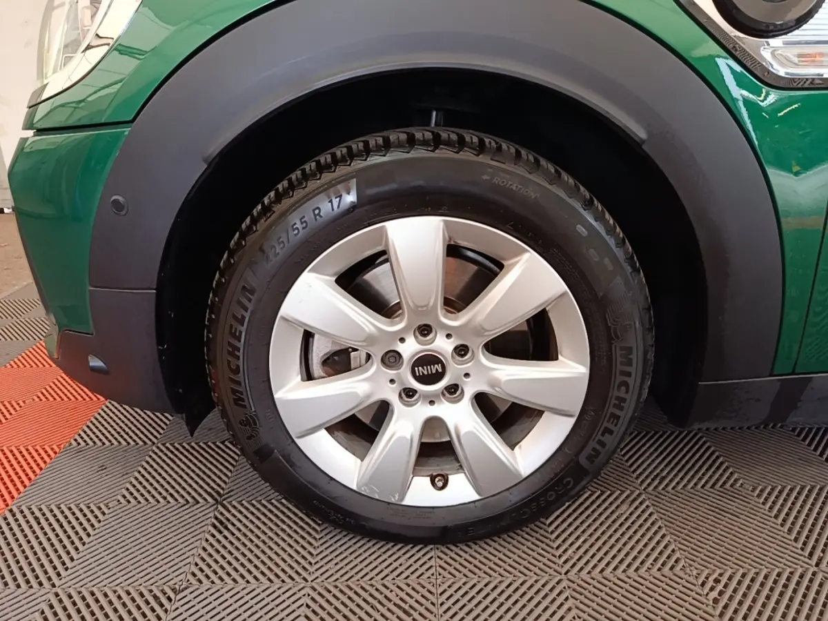 Gros plan sur la roue avant gauche d'une MINI Countryman verte avec jante argentée et pneu Michelin.