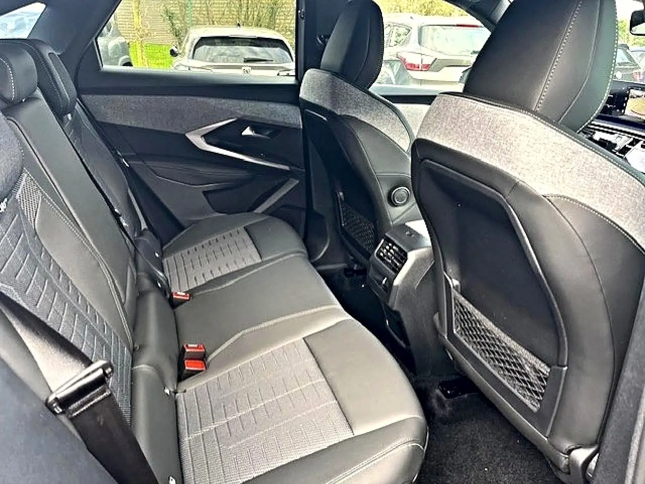 Vue intérieure arrière du Peugeot 3008 gris Artense, montrant les sièges en cuir et tissu avec accoudoirs et aérateurs centraux.