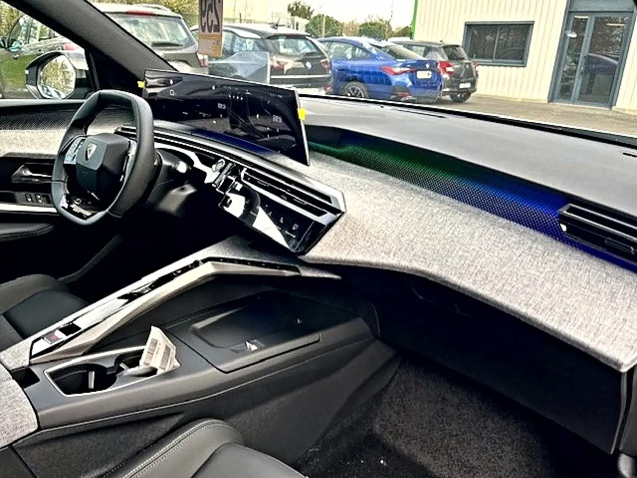 Vue intérieure côté passager du Peugeot 3008 gris Artense 2025, tableau de bord moderne avec écran tactile incurvé.