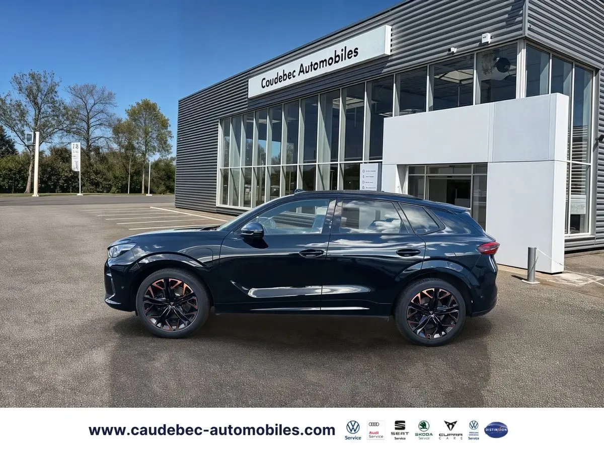 Vue de profil côté gauche d'une CUPRA Terramar noire avec jantes alliage 20 pouces cuivrées, stationnée devant un showroom.