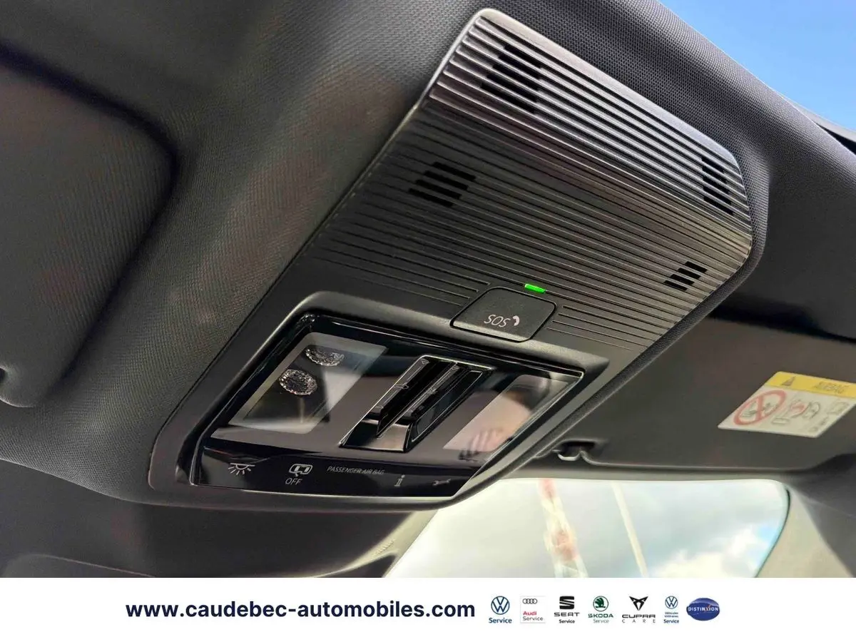 Vue intérieure en gros plan du panneau de commandes au plafond noir avec bouton SOS et éclairage intégré du CUPRA Terramar 2024.