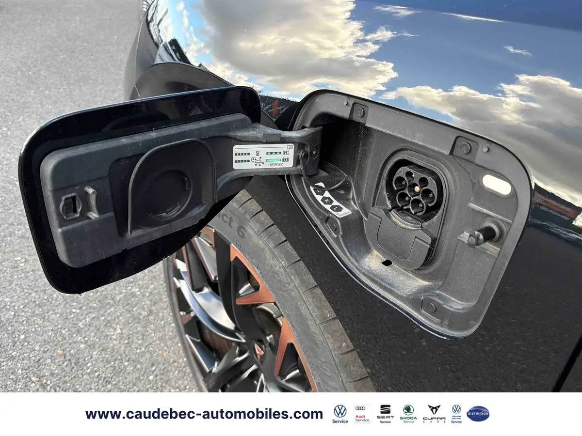 Prise de recharge ouverte côté gauche d’une CUPRA Terramar noire, jante alliage 20 pouces avec accents cuivrés visible.
