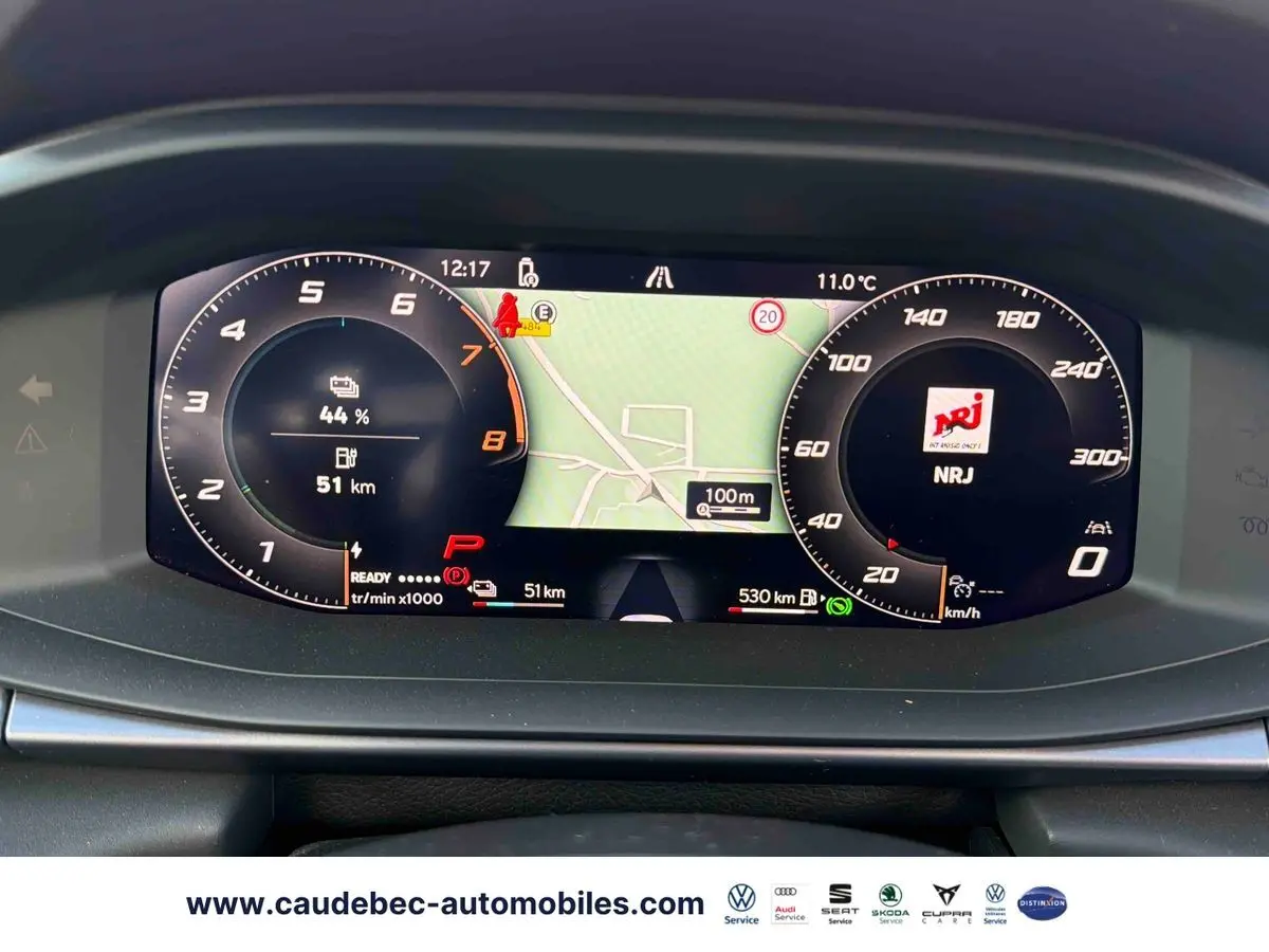 Vue rapprochée du tableau de bord numérique de la CUPRA Terramar 2024 affichant la navigation et l'autonomie batterie.