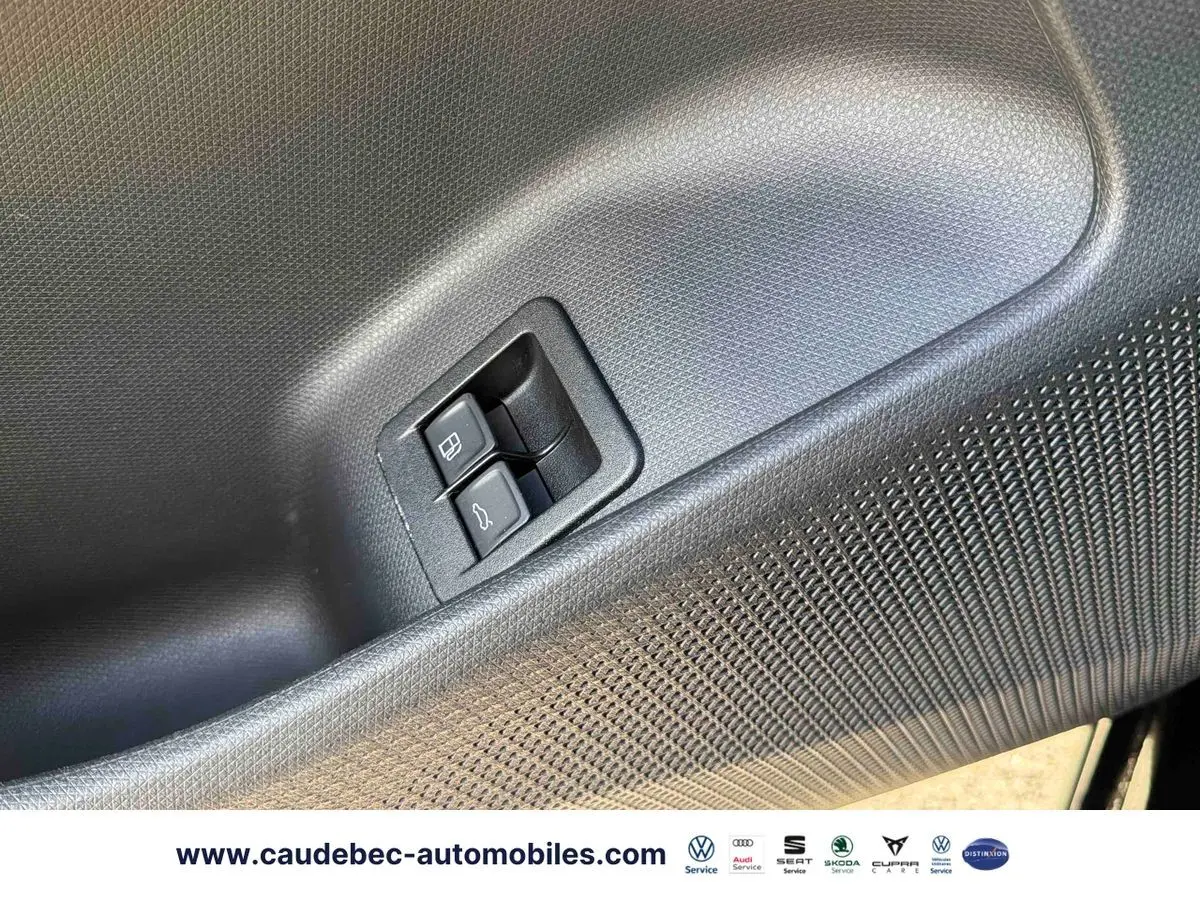 Gros plan sur les boutons d'ouverture de la trappe à carburant et du coffre, sur la porte intérieure noire du CUPRA Terramar.