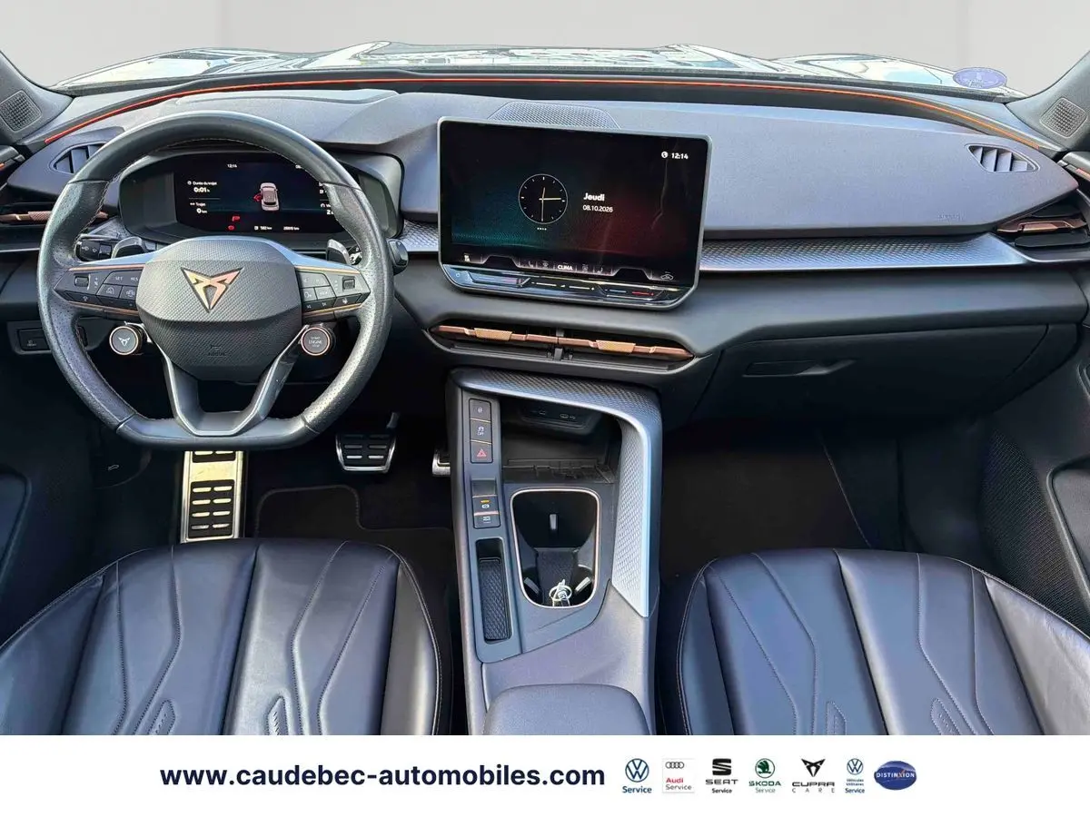 Vue intérieure avant du tableau de bord et volant noir de la CUPRA Terramar avec écran tactile central et sièges cuir noirs.
