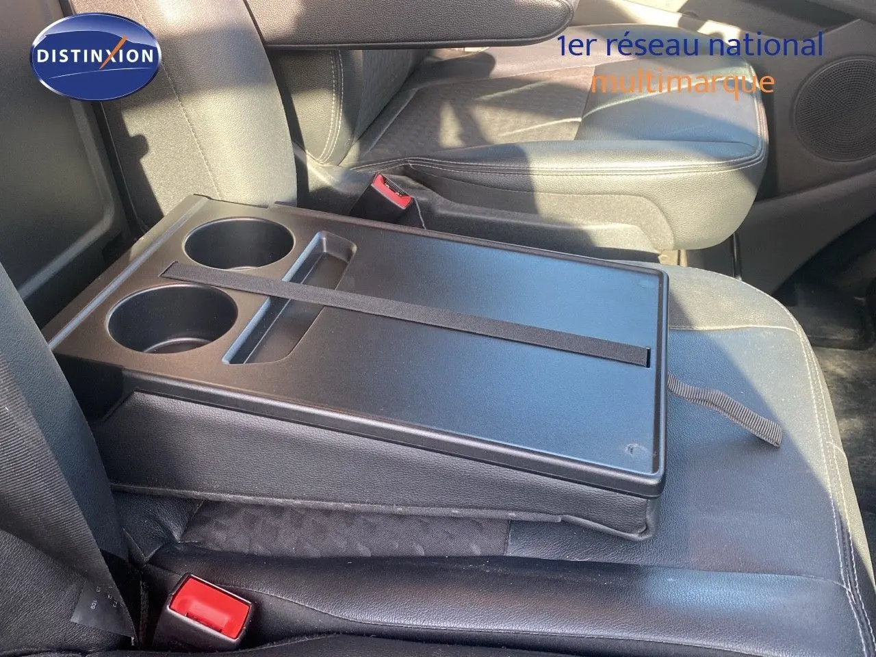 Plateau avec porte-gobelets sur la banquette avant en cuir noir du Ford Transit Custom Fourgon gris Magnetic 2023.