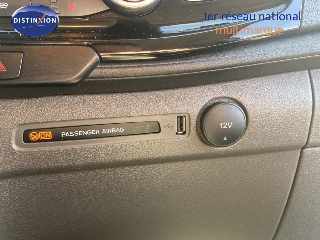 Détail du tableau de bord du Ford Transit Custom gris, montrant l'indicateur airbag passager et une prise 12V.
