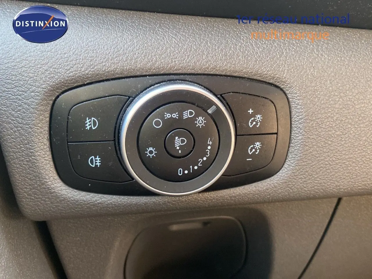 Gros plan sur le bouton de réglage des phares du Ford Transit Custom gris Magnetic, version 2023.