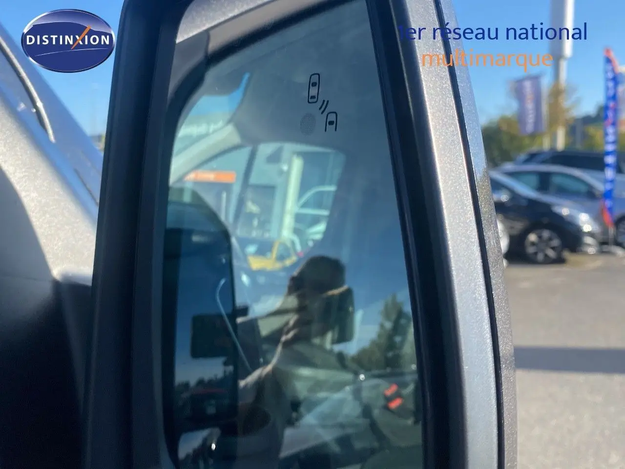 Rétroviseur côté droit du Ford Transit Custom gris magnetic, avec indication d'alerte d'angle mort visible.