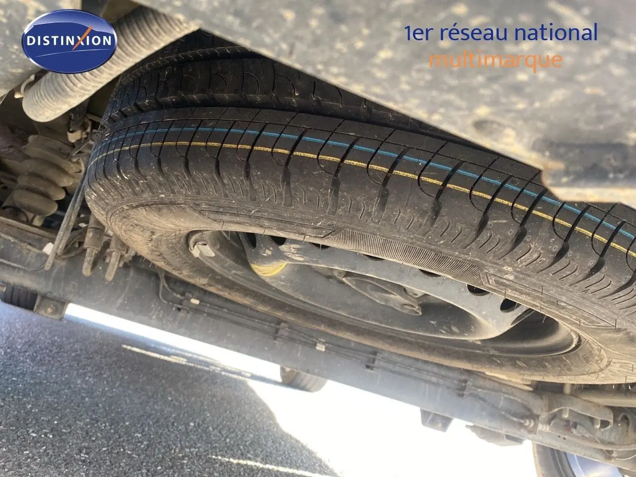 Gros plan sous un Ford Transit Custom gris magnetic 2023 montrant la roue de secours et la suspension arrière.