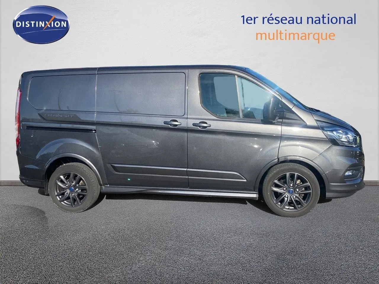 Vue latérale droite d'un Ford Transit Custom Fourgon gris magnetic 2023 avec jantes alliage noires sport.