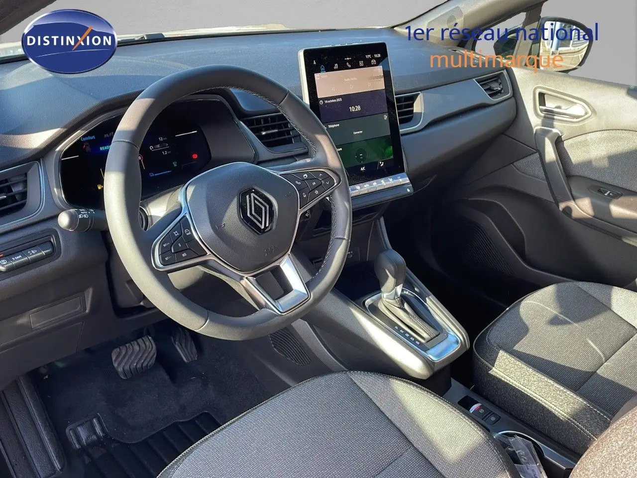 Intérieur avant du Renault Captur E-Tech gris rafale, volant multifonction et écran tactile vertical au centre.