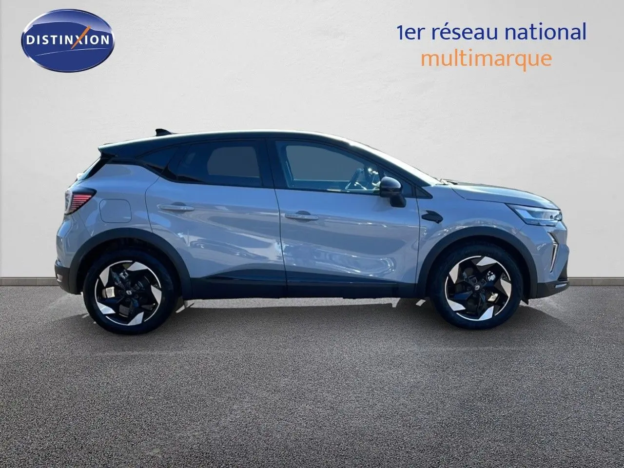 Profil droit du Renault Captur E-Tech hybride gris rafale avec toit noir et jantes noires distinctives.