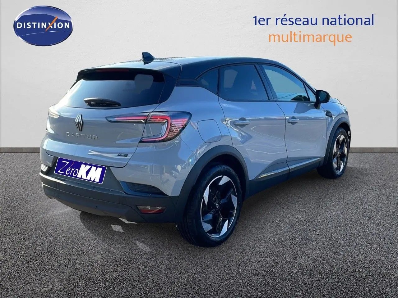 Renault Captur E-Tech hybride gris Rafale avec toit noir, vue 3/4 arrière côté droit, jantes noires distinctives.