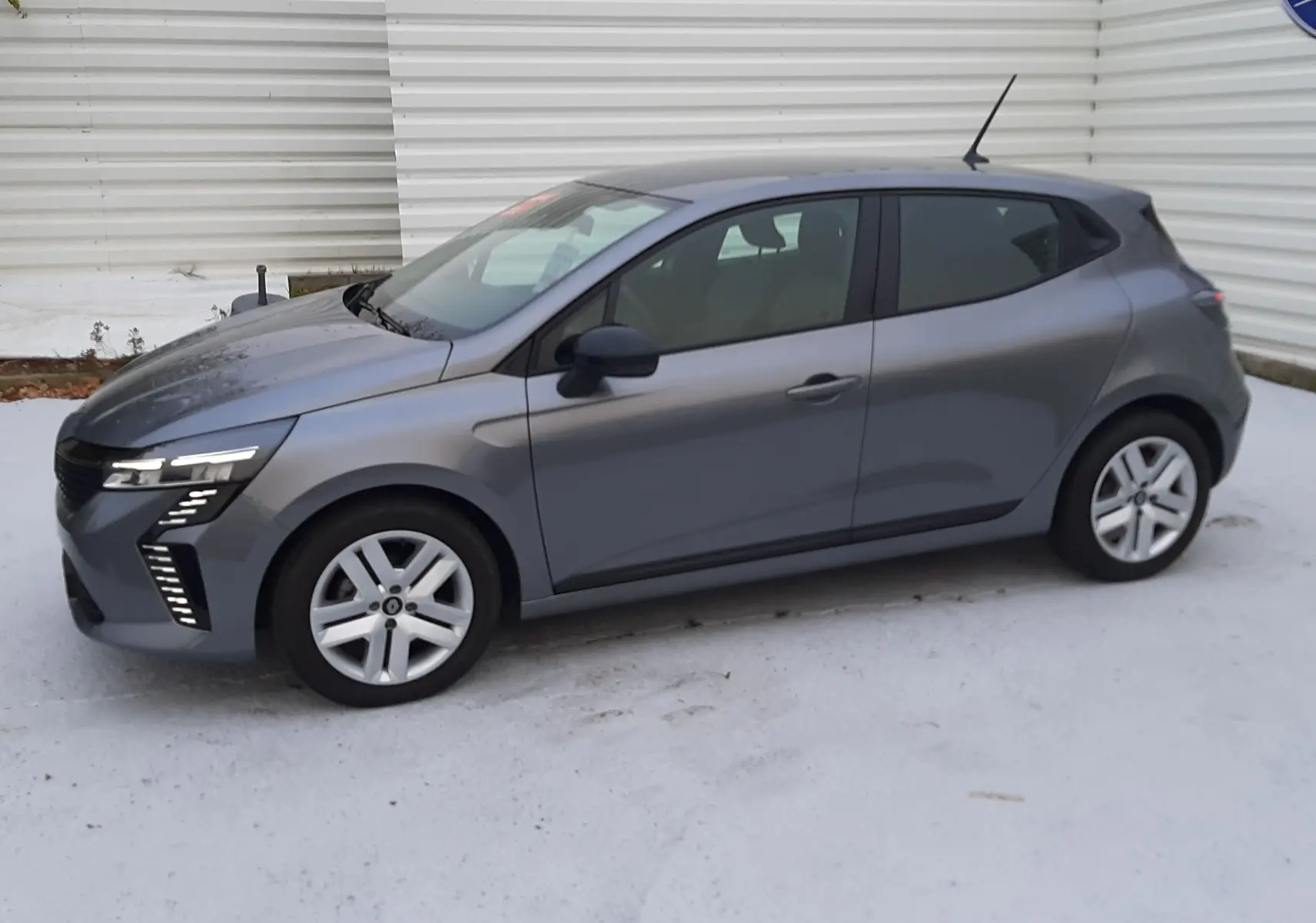 Profil côté gauche d'une Renault Clio V E-Tech Full Hybrid 145 Evolution gris schiste, avec feux LED distinctifs avant.