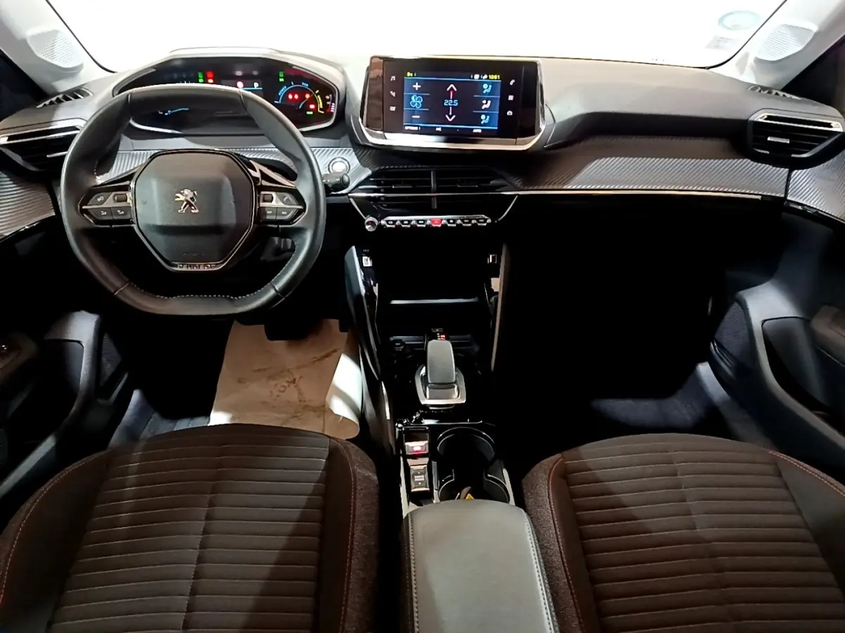 Vue intérieure avant du Peugeot 208 Electrique Active Business 2021, tableau de bord moderne avec écran tactile central et volant cuir.