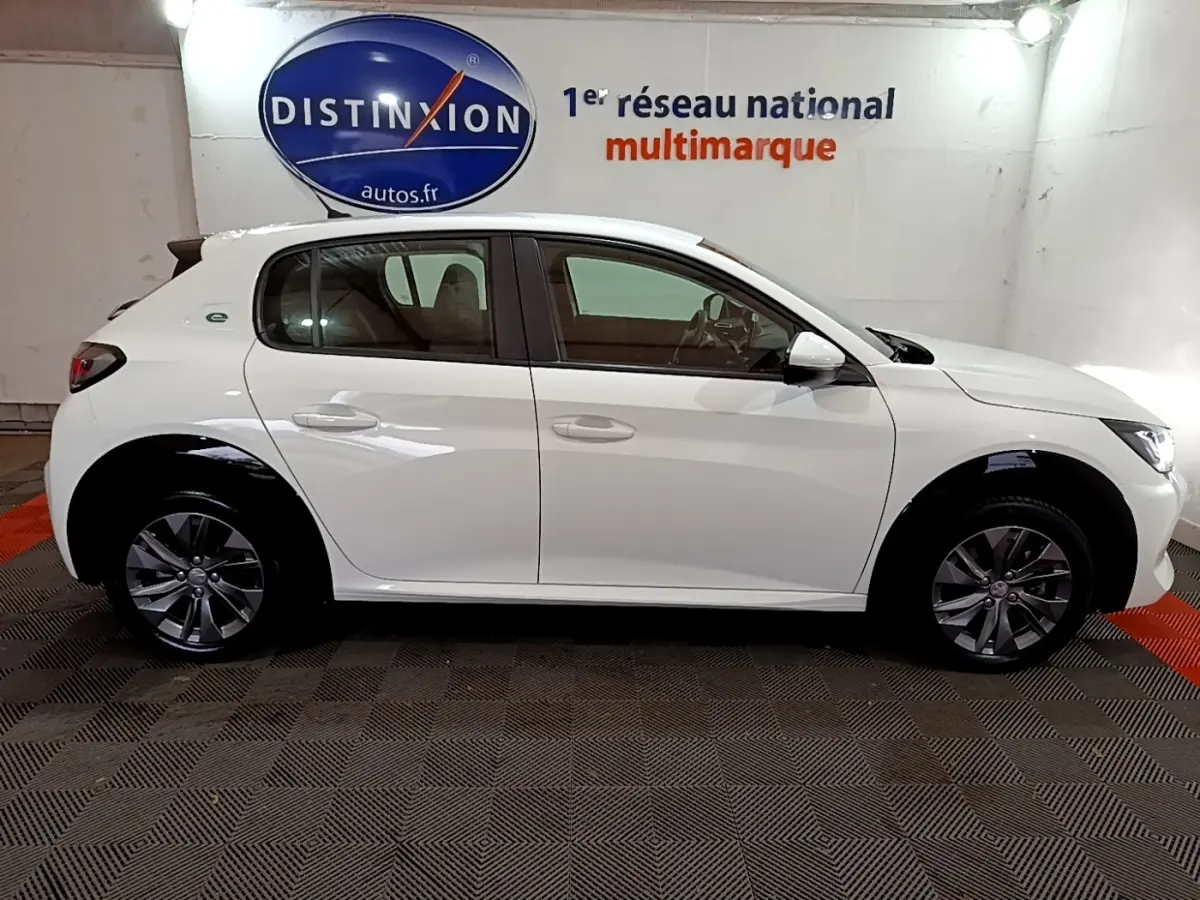 Peugeot 208 électrique blanche vue de profil côté gauche, avec jantes alliage et logo "e" arrière.