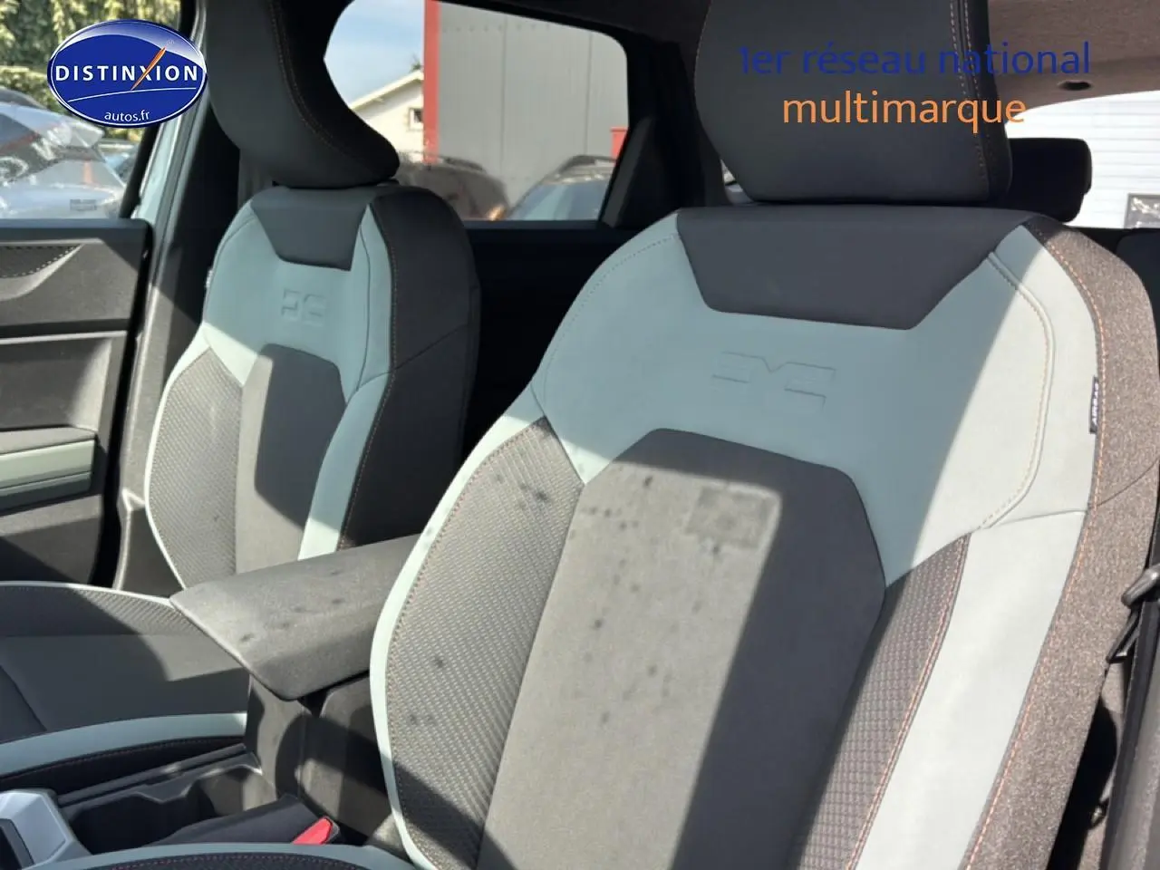 Vue intérieure rapprochée des sièges avant gris clair et foncé du Dacia Bigster avec accoudoir central visible.