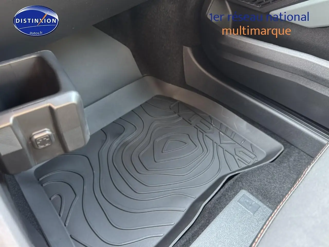 Détail de la moquette et du bac de rangement côté passager du Dacia Bigster gris schiste, intérieur sobre et fonctionnel.