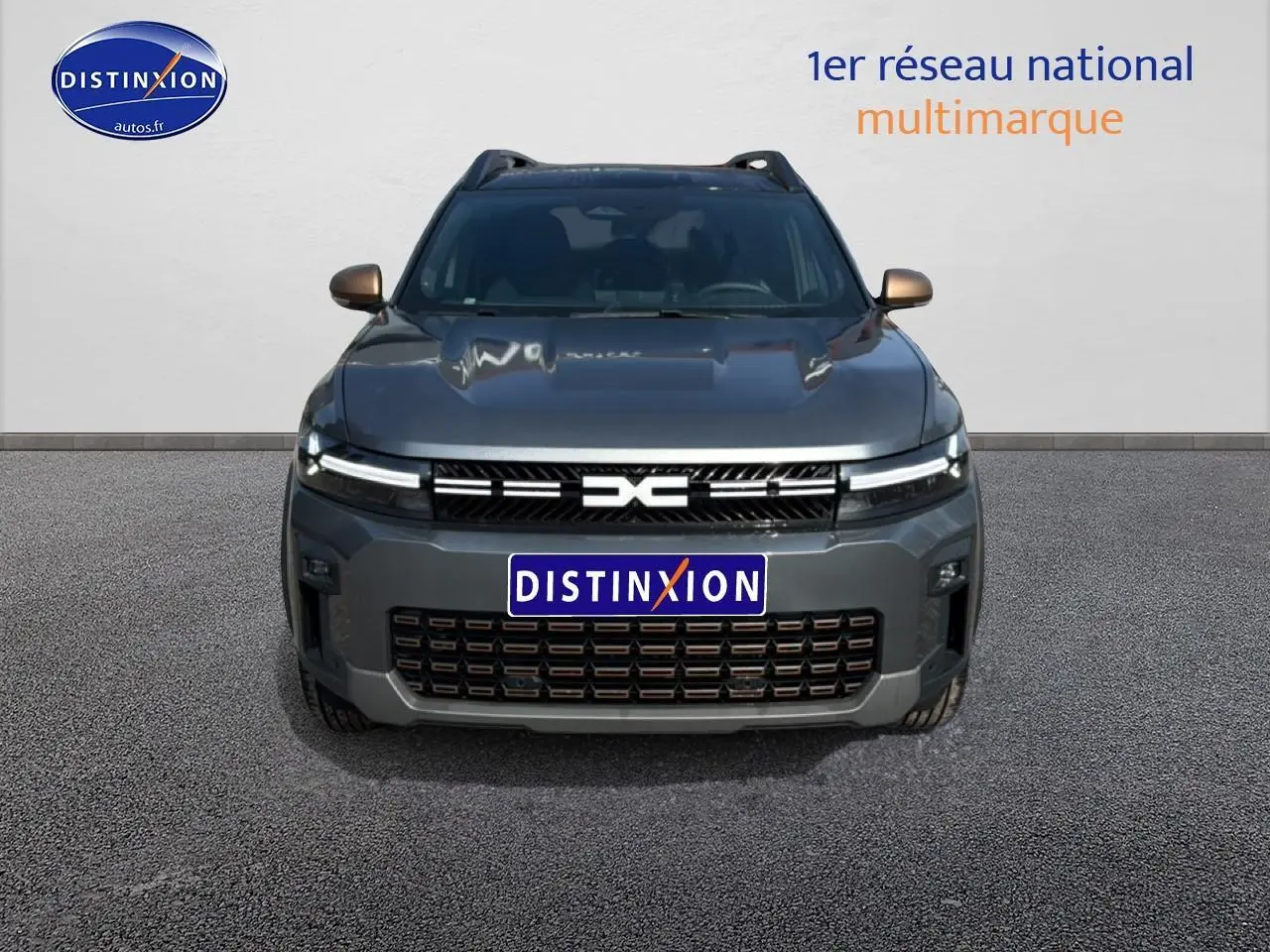 Vue frontale du Dacia Bigster gris schiste avec calandre distinctive et phares LED allumés.