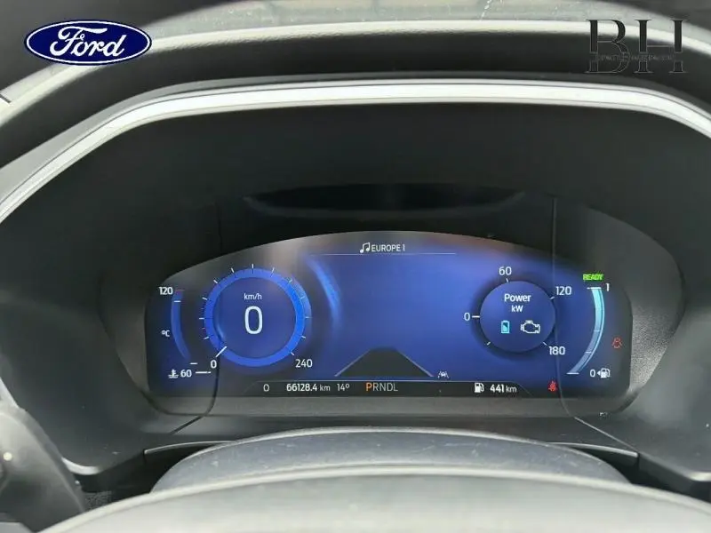 Vue rapprochée du tableau de bord numérique bleu du Ford Kuga 2023, affichant vitesse et puissance.