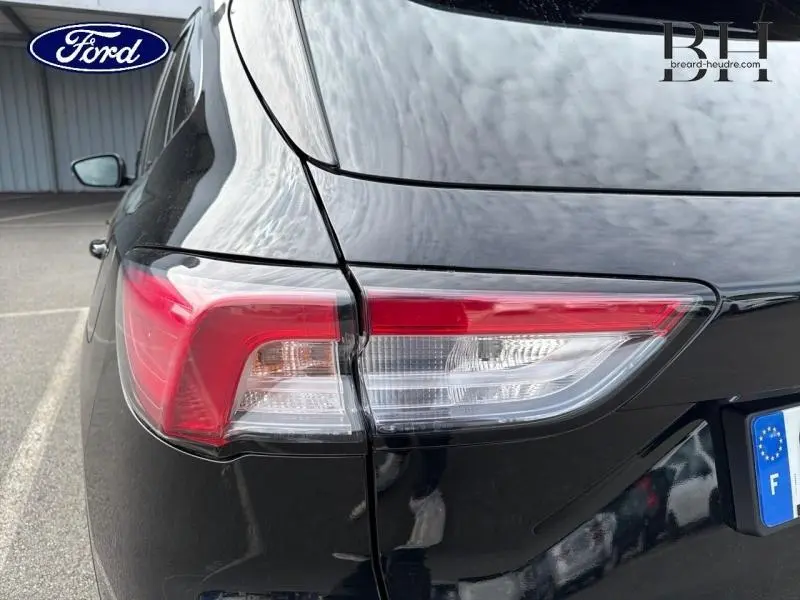 Gros plan sur le feu arrière droit du Ford Kuga 2023 noir Agate métallisé, soulignant ses lignes modernes et épurées.