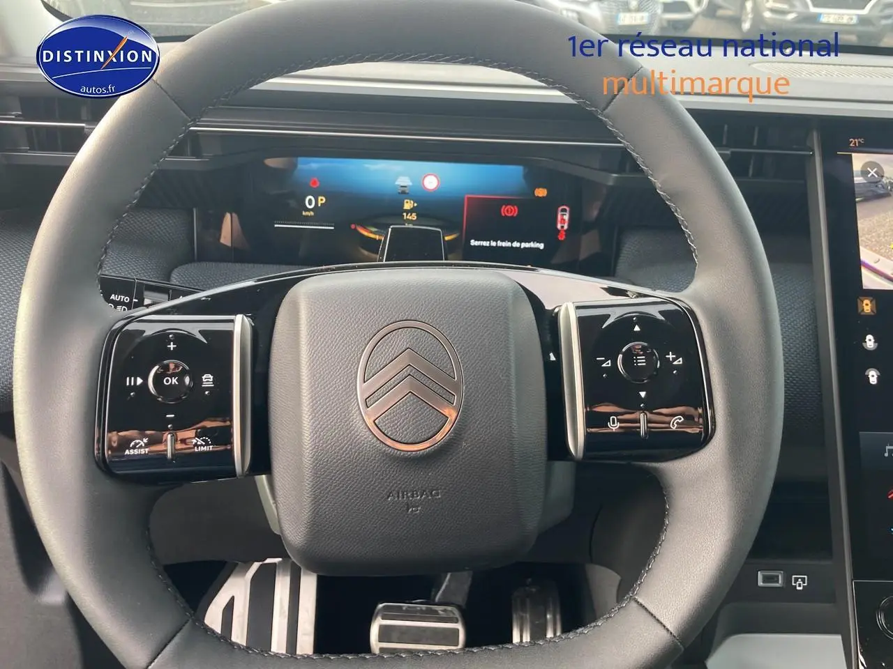 Vue rapprochée du volant noir du Citroën C5 Aircross 2026 avec commandes multifonctions et tableau de bord numérique.