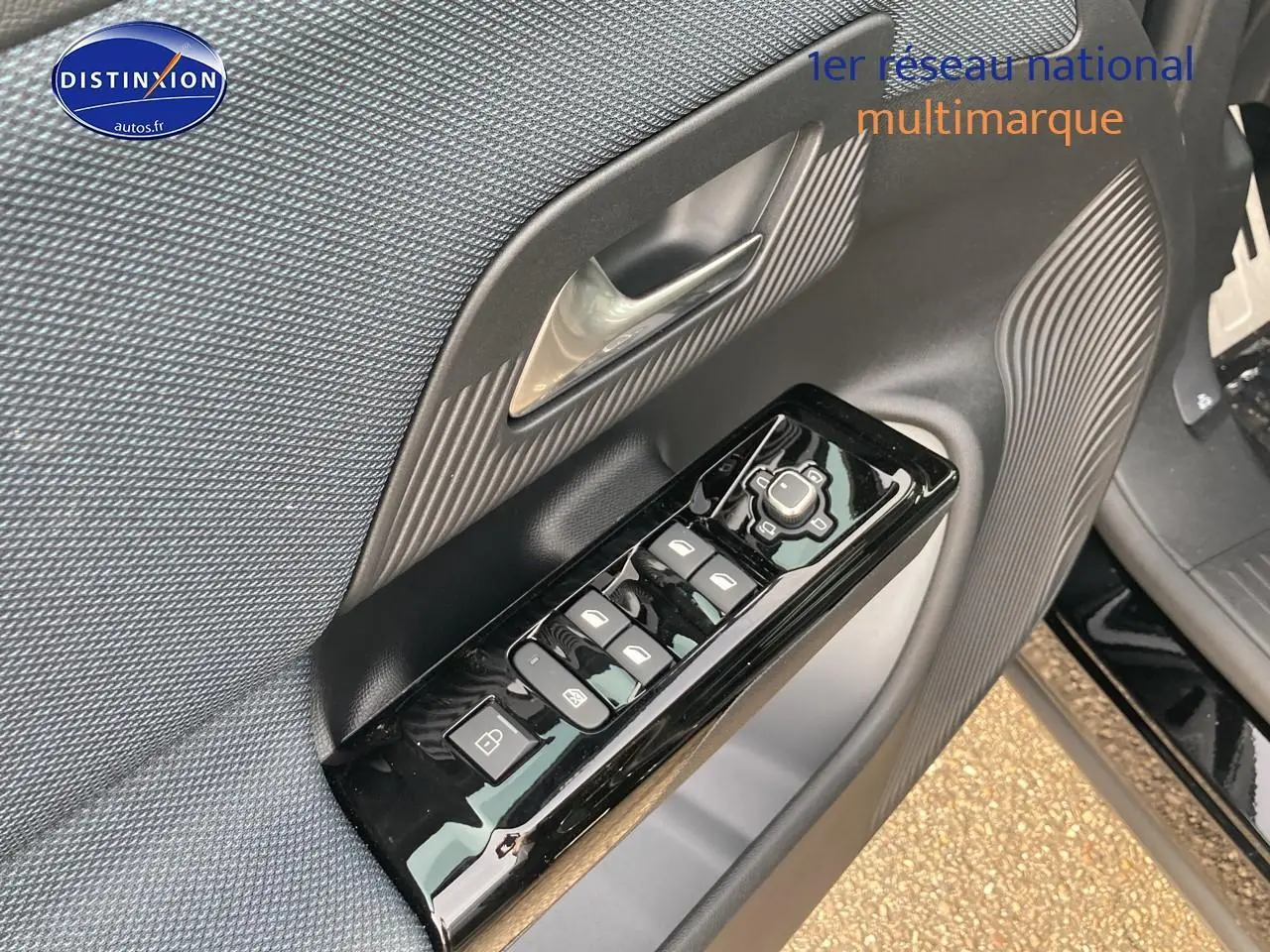 Gros plan sur la porte avant gauche noire du Citroën C5 Aircross 2026 avec commandes de vitres et rétroviseurs.