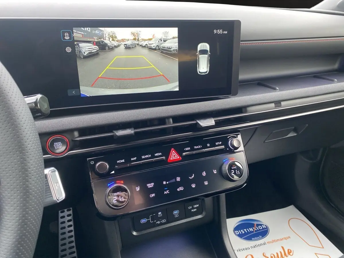 Vue intérieure du tableau de bord du Hyundai Tucson 2026 avec écran tactile affichant la caméra de recul et commandes climatisation.