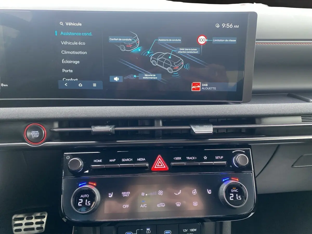 Vue rapprochée du tableau de bord du Hyundai Tucson gris foncé, avec écran tactile et commandes climatisation digitales.