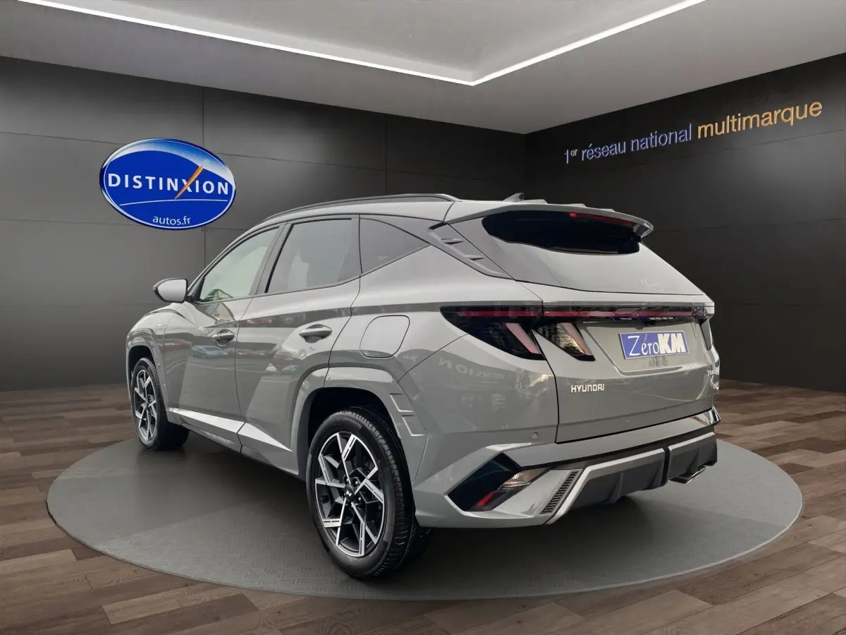 Vue 3/4 arrière droite du Hyundai Tucson gris foncé avec jantes alliage et feux arrière LED étirés.