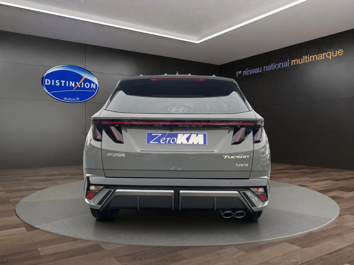 Vue arrière d’un Hyundai Tucson gris foncé hybride avec feux LED distinctifs et double sortie d’échappement.