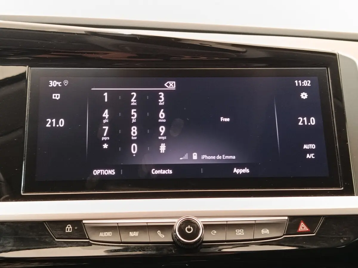Écran tactile central affichant le clavier téléphonique et la température à 21°C dans l’Opel Grandland Hybride 2023.