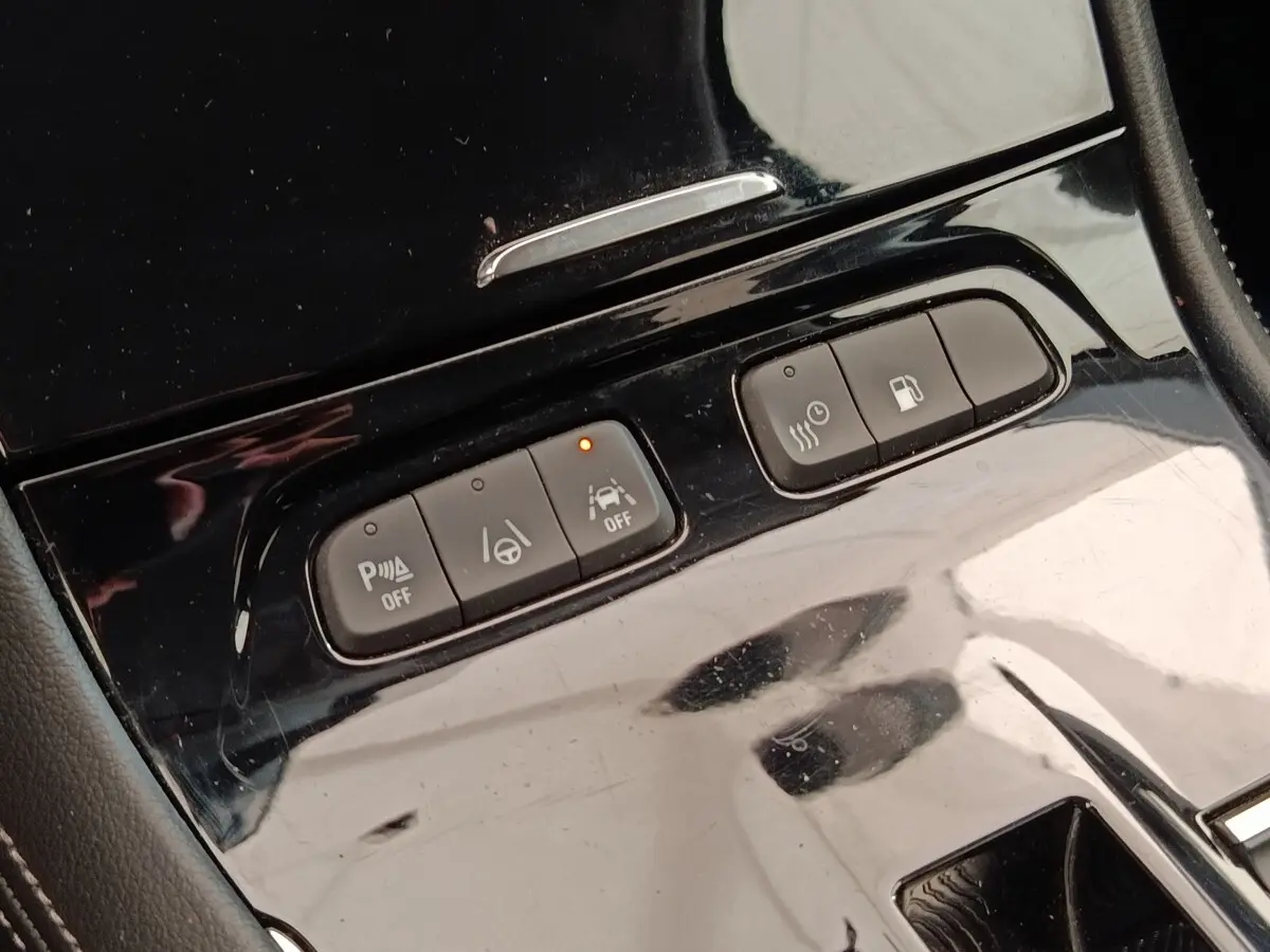 Gros plan sur les boutons de commande noirs brillants du tableau de bord central de l’Opel Grandland hybride 2023.