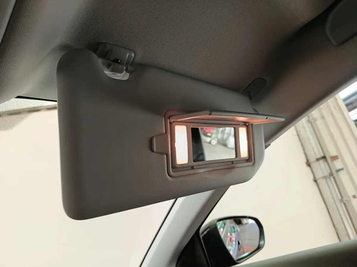 Détail du pare-soleil côté conducteur avec miroir éclairé dans l’habitacle clair de l’Opel Grandland noir.